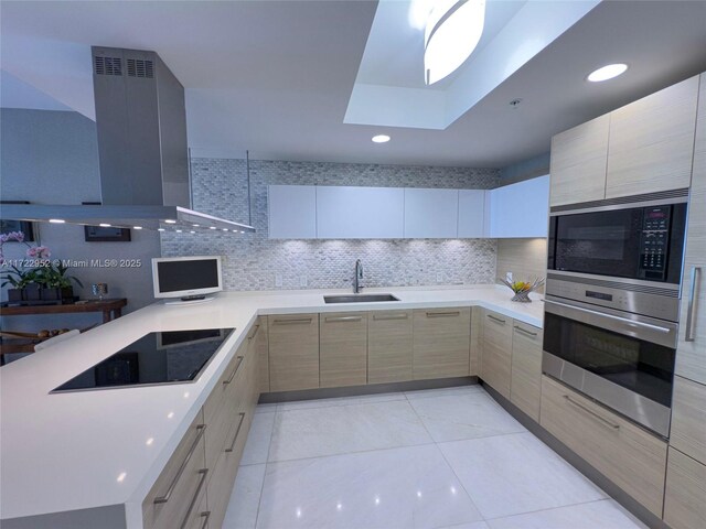 kitchen featuring light brown cabinetry, sink, stainless steel appliances, decorative backsplash, and exhaust hood