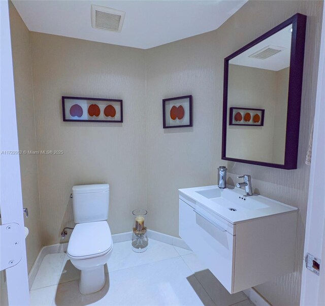 bathroom with sink, toilet, and tile patterned flooring