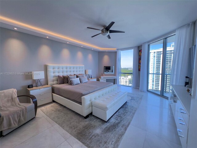 tiled bedroom featuring expansive windows, access to outside, and ceiling fan