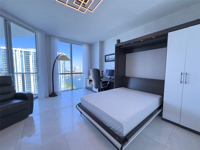 bedroom featuring light tile patterned floors and a wall of windows