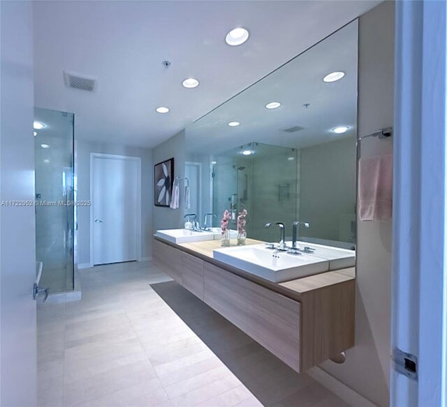 bathroom with vanity and a shower with door