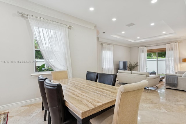 dining room with a raised ceiling, visible vents, crown molding, and baseboards