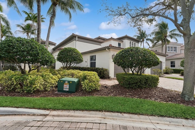 view of front facade with a garage, decorative driveway, and stucco siding