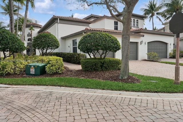 mediterranean / spanish house with a tile roof, decorative driveway, and stucco siding