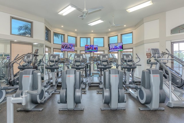 gym featuring ceiling fan and a high ceiling