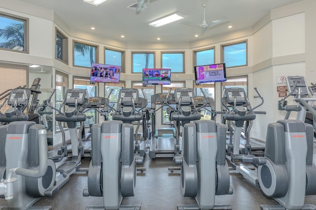 exercise room with a towering ceiling, visible vents, and recessed lighting