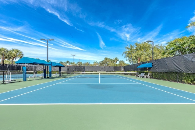 view of tennis court featuring fence