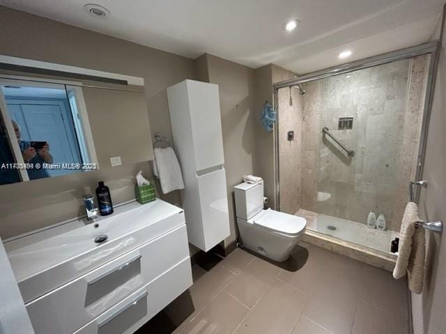 bathroom featuring tile patterned floors, vanity, toilet, and an enclosed shower