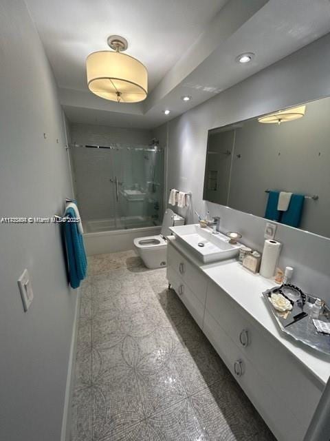 full bathroom featuring vanity, a raised ceiling, toilet, and combined bath / shower with glass door