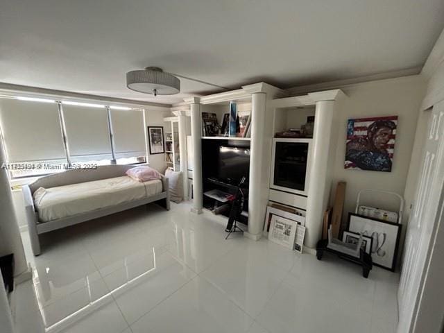 bedroom with light tile patterned floors and ornate columns