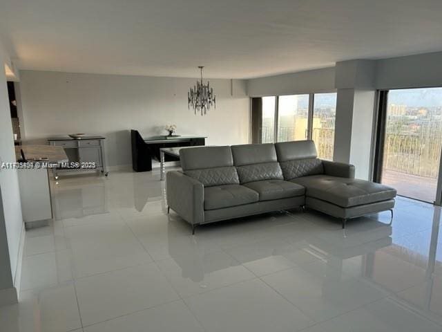 tiled living room with a notable chandelier