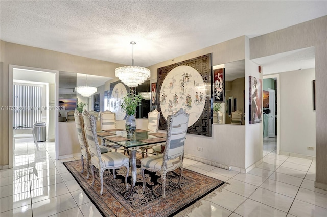 tiled dining room featuring a textured ceiling and an inviting chandelier