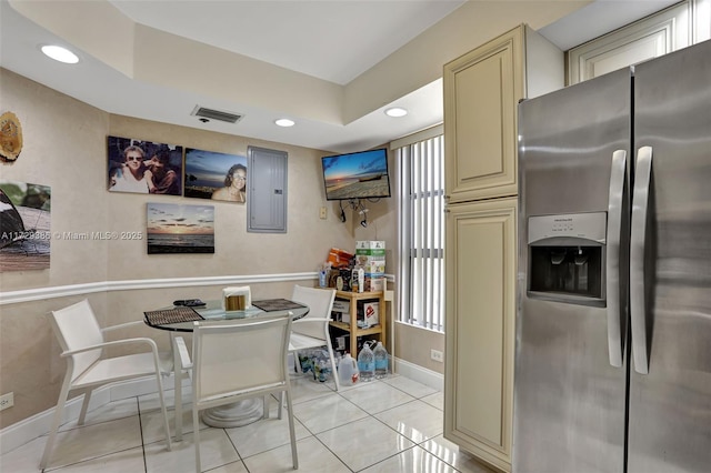 kitchen with stainless steel fridge with ice dispenser, light tile patterned floors, a tray ceiling, electric panel, and cream cabinetry