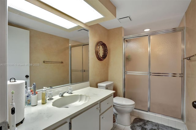 bathroom featuring vanity, walk in shower, tile patterned floors, and toilet