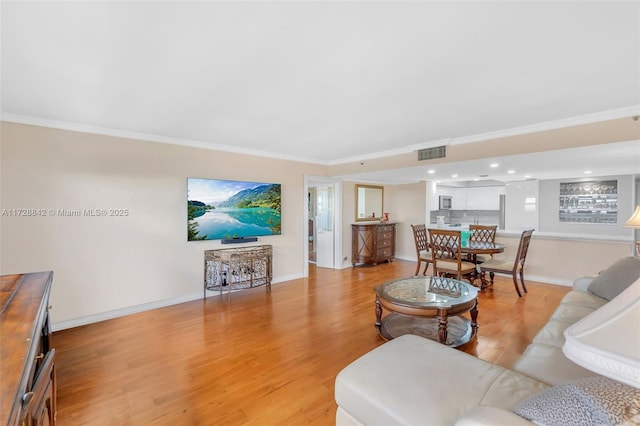 living room with crown molding and light hardwood / wood-style floors