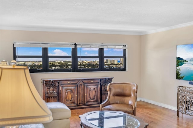 sitting room featuring crown molding and light hardwood / wood-style floors