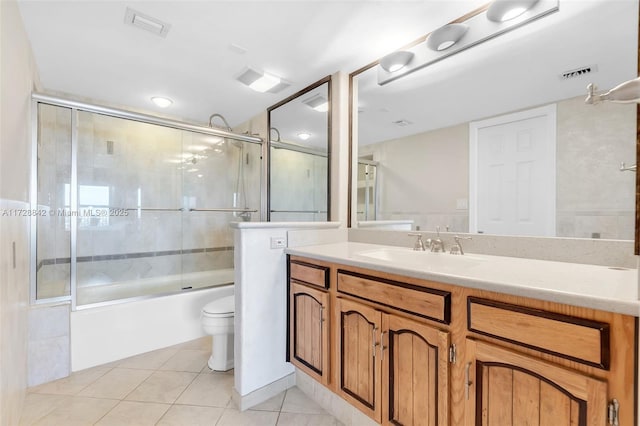 full bathroom with tile patterned flooring, vanity, shower / bath combination with glass door, and toilet