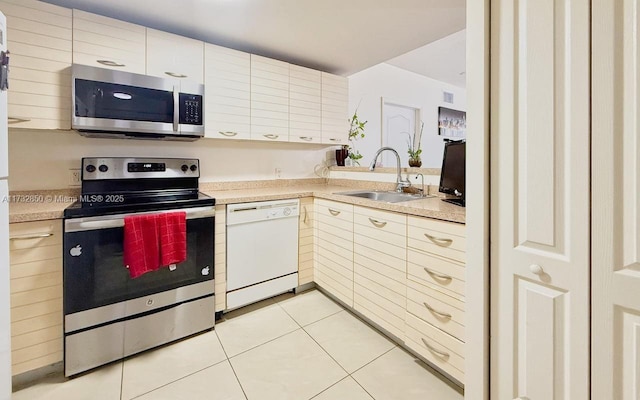 kitchen featuring appliances with stainless steel finishes, sink, and light tile patterned floors