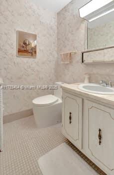 bathroom with tile patterned flooring, vanity, and toilet