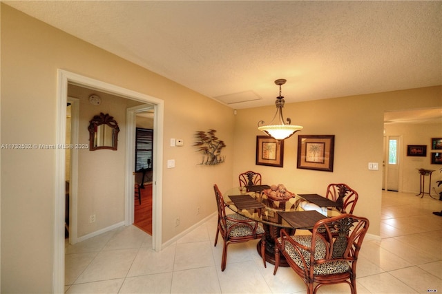 tiled dining area with a textured ceiling