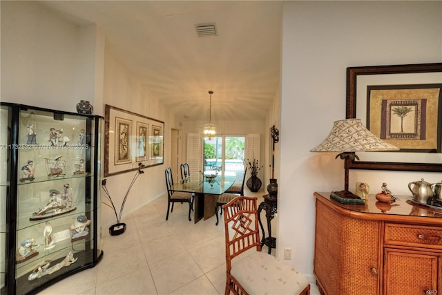 dining space featuring lofted ceiling, light tile patterned floors, and an inviting chandelier