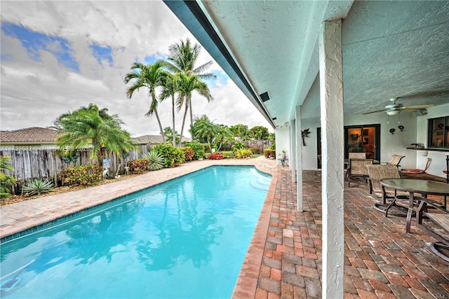 view of swimming pool with ceiling fan and a patio area