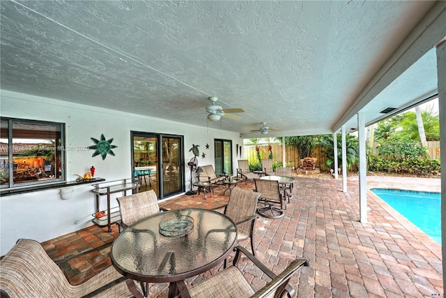 view of patio / terrace with a fenced in pool and ceiling fan