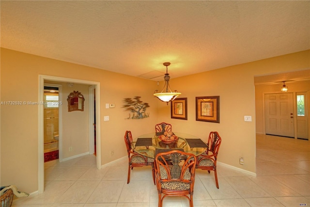 dining area with light tile patterned floors and a textured ceiling