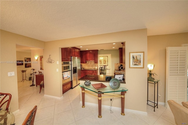 kitchen with a breakfast bar area, backsplash, stainless steel appliances, light tile patterned flooring, and kitchen peninsula