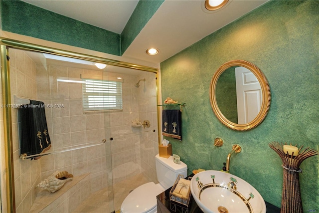 bathroom featuring toilet, an enclosed shower, and sink