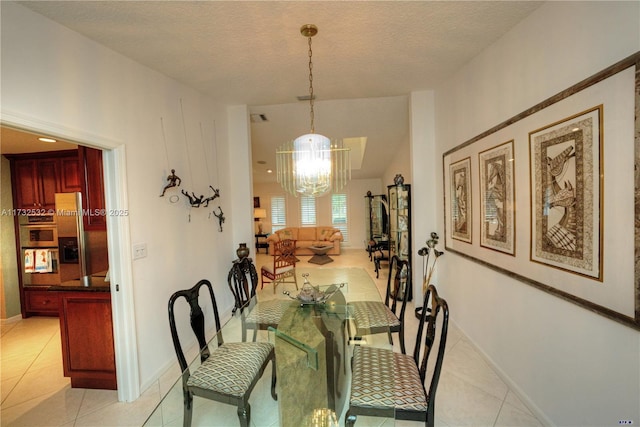 dining room featuring an inviting chandelier, light tile patterned floors, and a textured ceiling