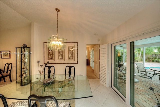 dining room featuring a notable chandelier, light tile patterned floors, vaulted ceiling, and a textured ceiling