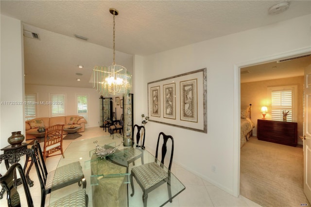 dining space with light tile patterned floors, a notable chandelier, and a textured ceiling