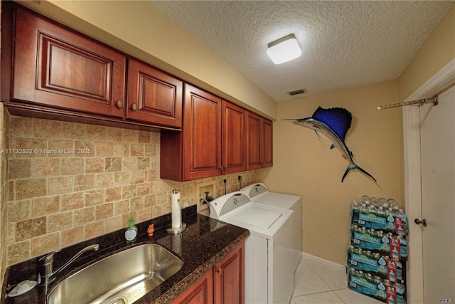 clothes washing area featuring sink, light tile patterned floors, independent washer and dryer, cabinets, and a textured ceiling