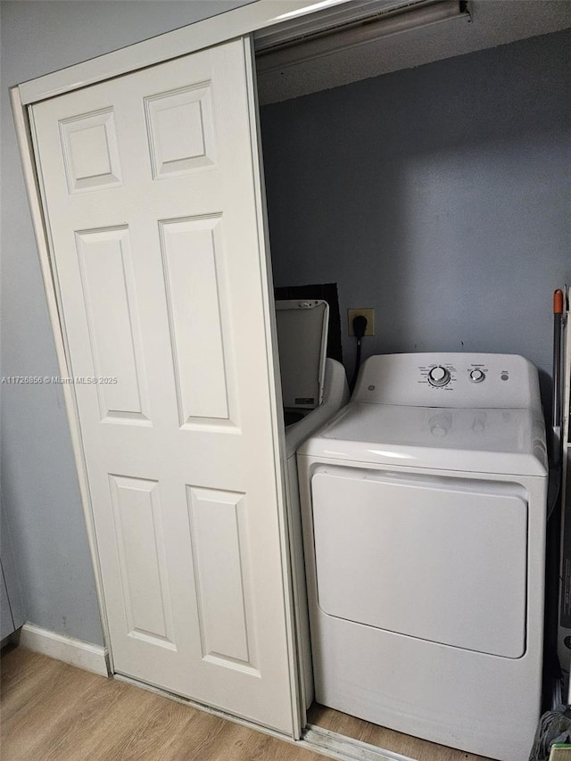 laundry area with washer / dryer and light hardwood / wood-style floors