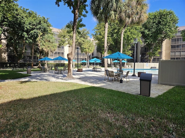 view of home's community with a patio, a swimming pool, and a lawn