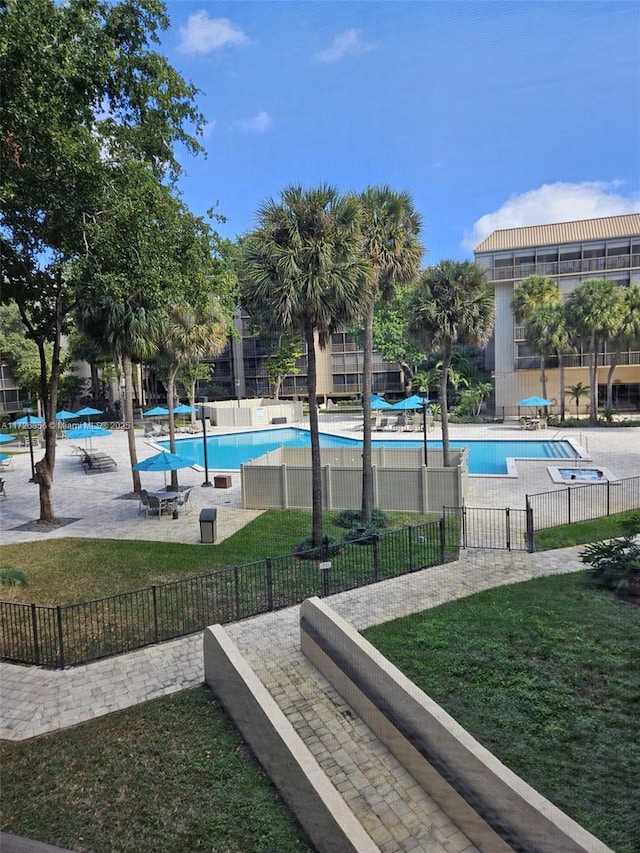 view of pool with a patio area and a lawn