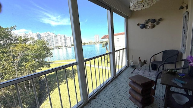 sunroom featuring a water view