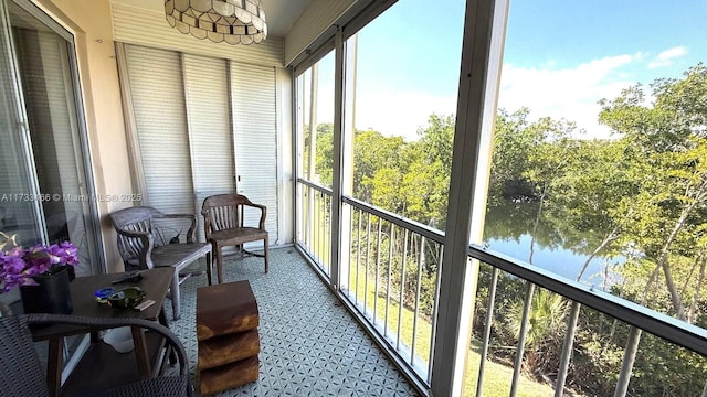 sunroom / solarium featuring a water view