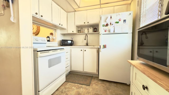 kitchen with white appliances, sink, butcher block countertops, and white cabinets