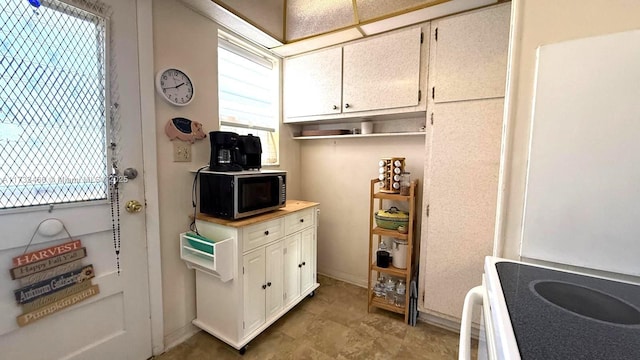 kitchen featuring white cabinetry, electric range oven, and plenty of natural light