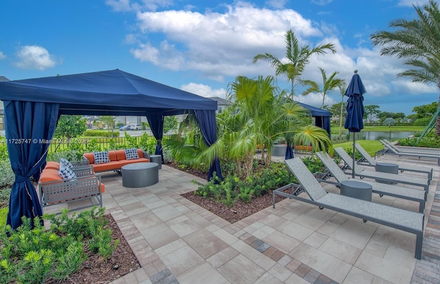 view of patio featuring a gazebo, an outdoor hangout area, and a water view