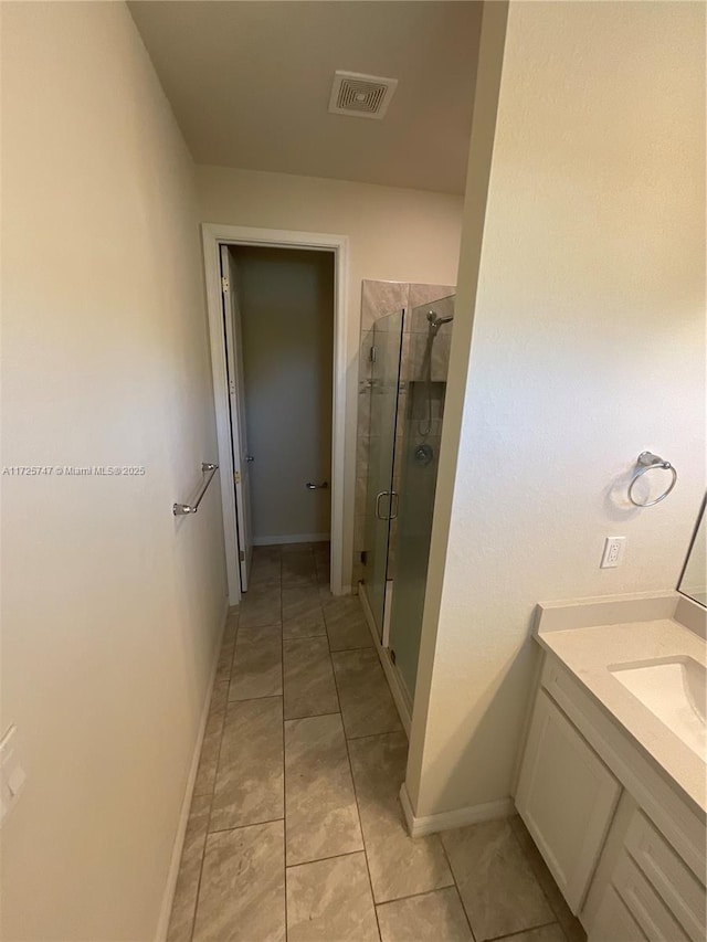 bathroom with tile patterned floors, visible vents, a shower stall, baseboards, and vanity