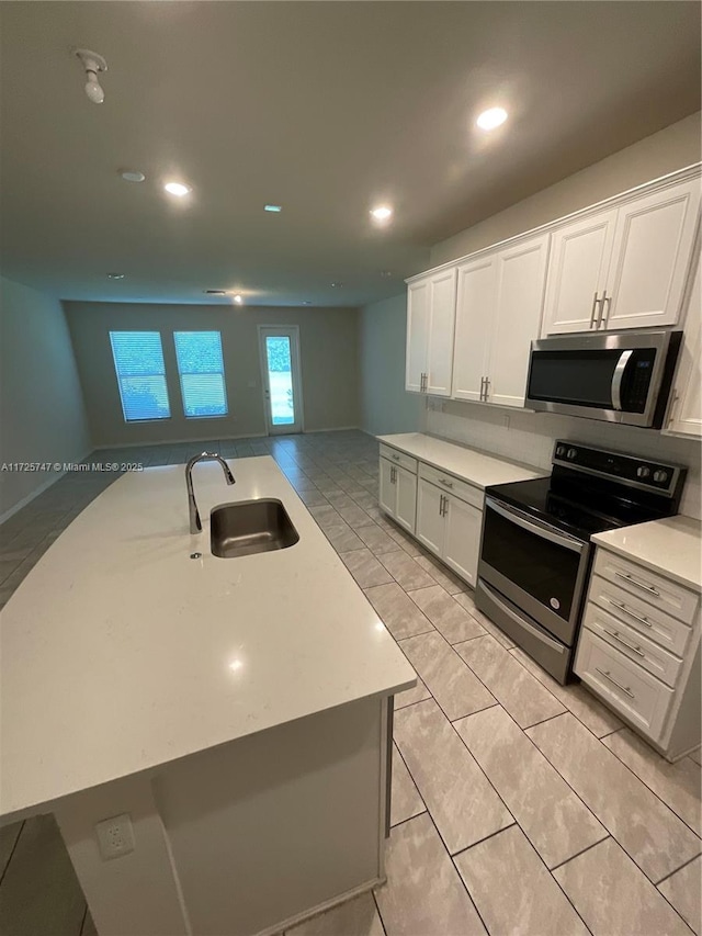 kitchen featuring recessed lighting, a sink, light countertops, white cabinets, and appliances with stainless steel finishes