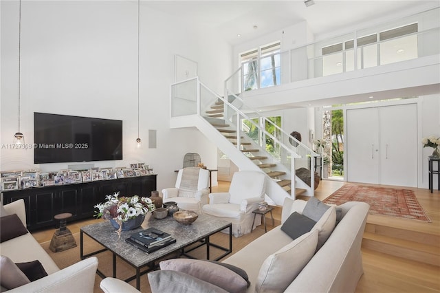 living room with hardwood / wood-style flooring, a wealth of natural light, and a high ceiling