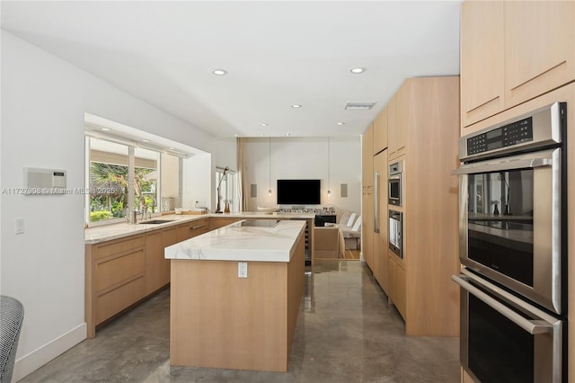 kitchen featuring double oven, light brown cabinets, concrete floors, and a center island