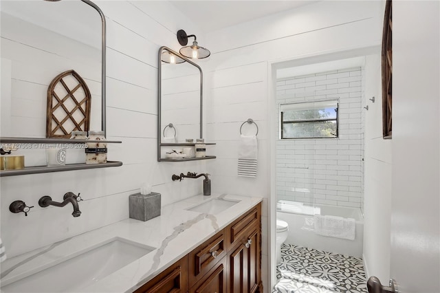 full bathroom with tiled shower / bath, vanity, and toilet