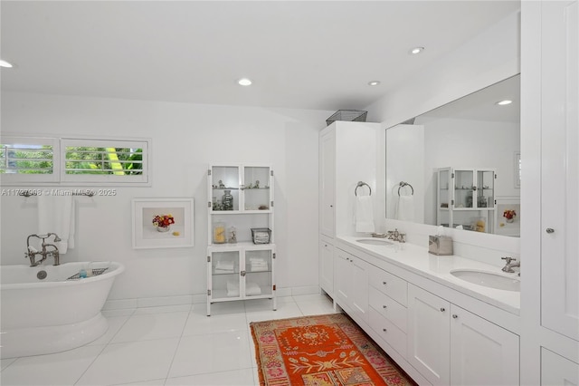 bathroom with tile patterned floors, a bath, and vanity