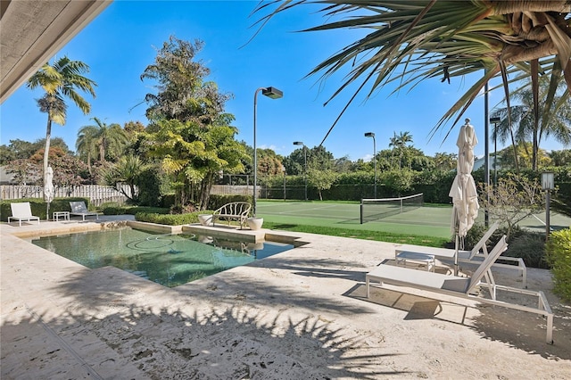 view of swimming pool with tennis court