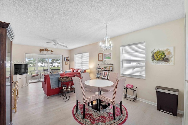 2751 E Golf Blvd Unit 2029, Pompano Beach, FL 33064 - dining area featuring light wood-style flooring, a textured ceiling, a chandelier, a ceiling fan, and baseboards